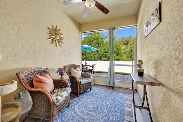 sunroom / solarium featuring ceiling fan