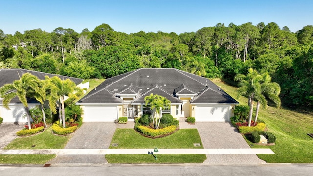 view of front of property featuring a garage, decorative driveway, and a front lawn