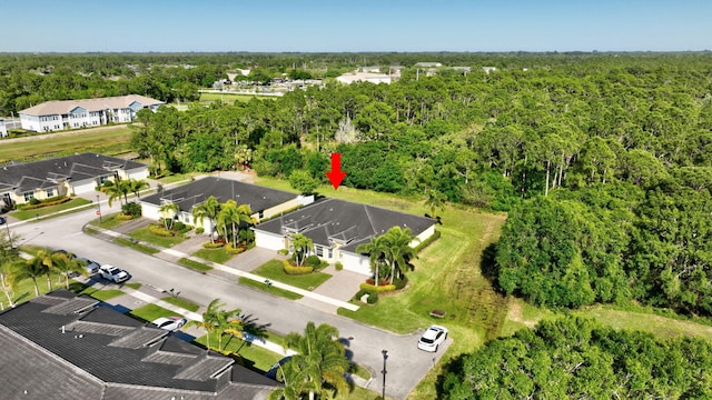 birds eye view of property featuring a forest view and a residential view