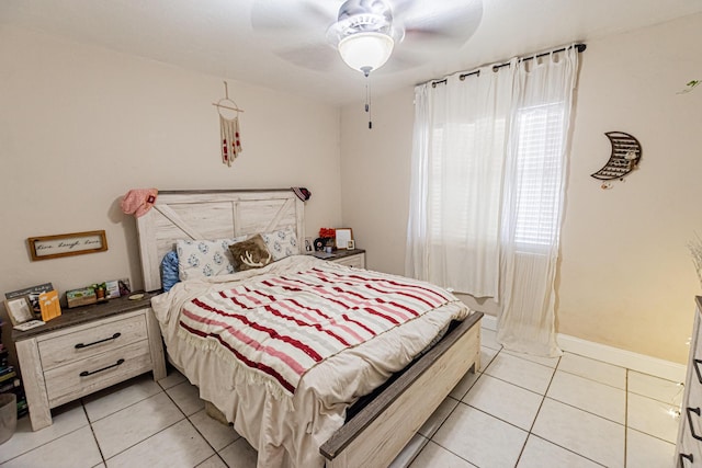 bedroom featuring light tile patterned flooring, a ceiling fan, and baseboards