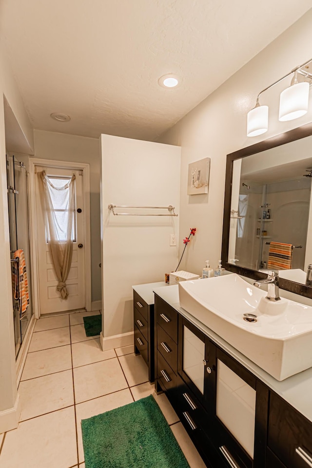 full bath featuring tile patterned floors, a shower stall, vanity, and baseboards