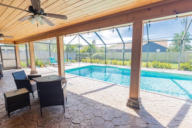 view of pool featuring glass enclosure, a patio, and a fenced backyard