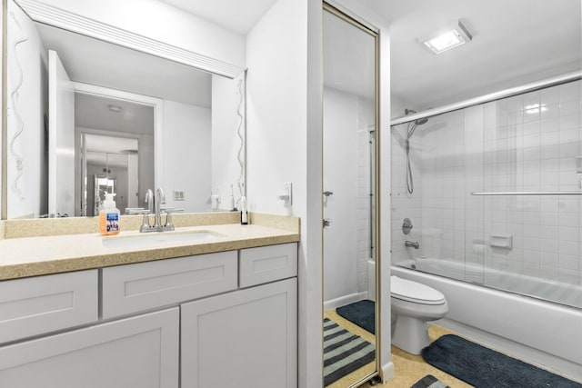 bathroom featuring enclosed tub / shower combo, vanity, and toilet