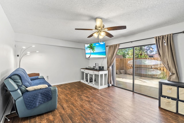 living area featuring hardwood / wood-style flooring, a ceiling fan, baseboards, and a textured ceiling