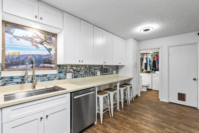 kitchen with dark wood-type flooring, a sink, washer and dryer, decorative backsplash, and dishwasher