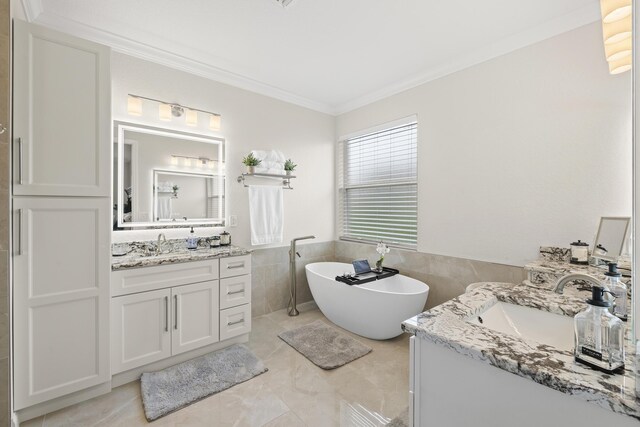 4113 Worlington Ter, Fort Pierce, FL 34947 - full bathroom with ornamental molding, two vanities, a freestanding bath, tile walls, and wainscoting
