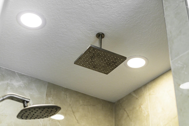 details featuring a textured ceiling and tiled shower