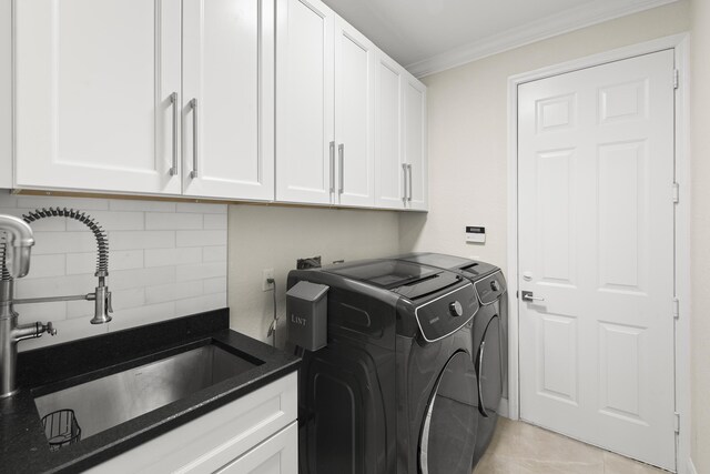 clothes washing area featuring a sink, washing machine and dryer, cabinet space, crown molding, and light tile patterned floors