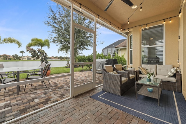 sunroom / solarium featuring a water view