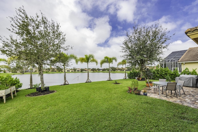 view of yard with a lanai, a patio, and a water view