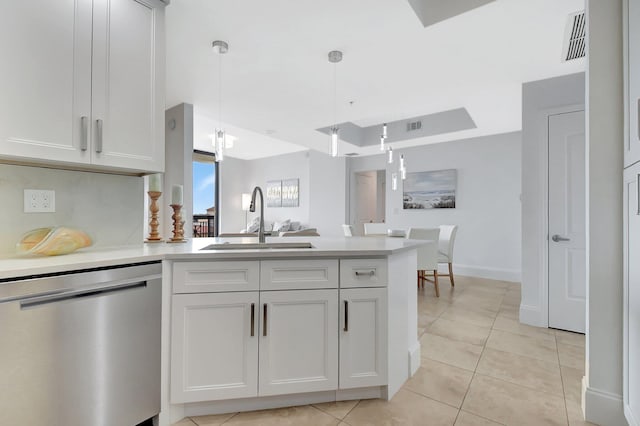 kitchen featuring open floor plan, a sink, a peninsula, and stainless steel dishwasher