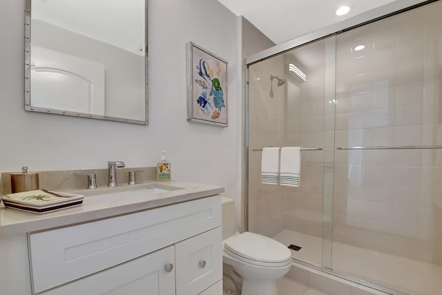 bathroom with vanity, a shower stall, and toilet