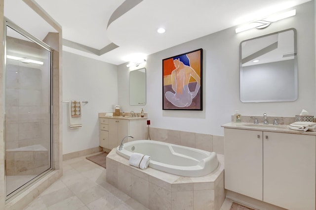 full bath featuring two vanities, a stall shower, a garden tub, and a sink