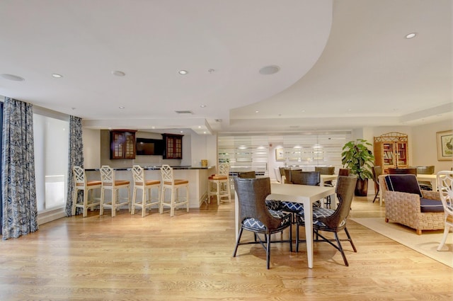 dining area featuring light wood-style floors, recessed lighting, a raised ceiling, and visible vents