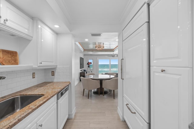 kitchen featuring dishwashing machine, visible vents, ornamental molding, and a raised ceiling