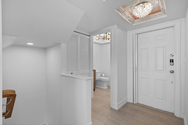 bathroom with a chandelier, baseboards, and wood finished floors