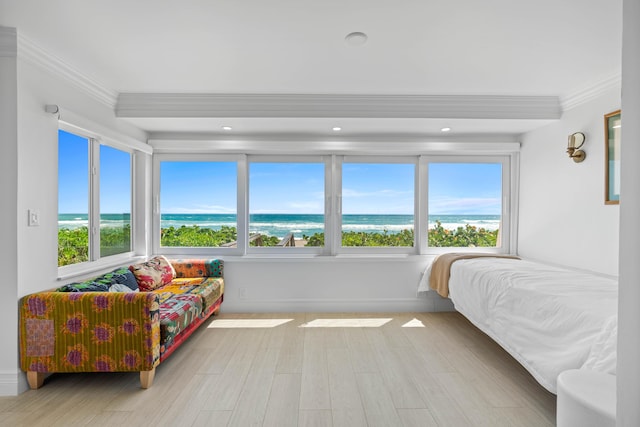 bedroom featuring ornamental molding, a water view, baseboards, and wood finished floors