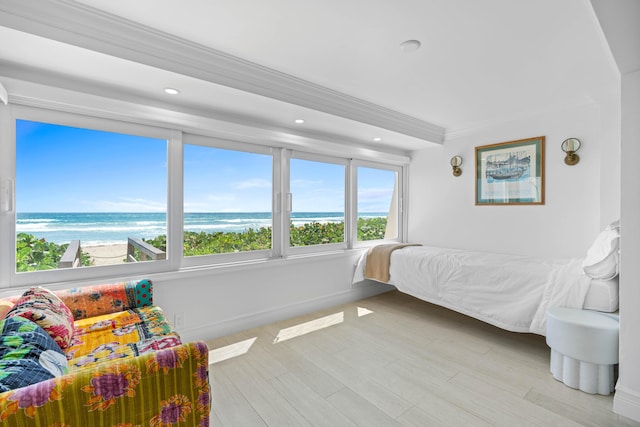 bedroom featuring a water view, baseboards, crown molding, and wood finished floors