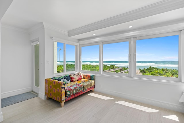 bedroom featuring ornamental molding, a water view, baseboards, and wood finished floors