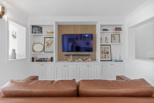 living area featuring built in shelves and crown molding