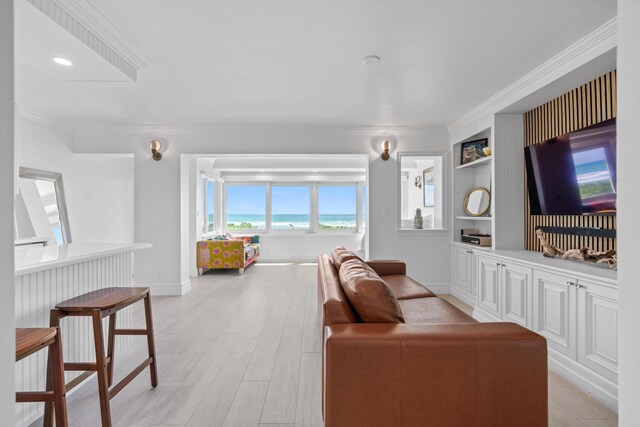 living area with built in features, baseboards, crown molding, and light wood finished floors