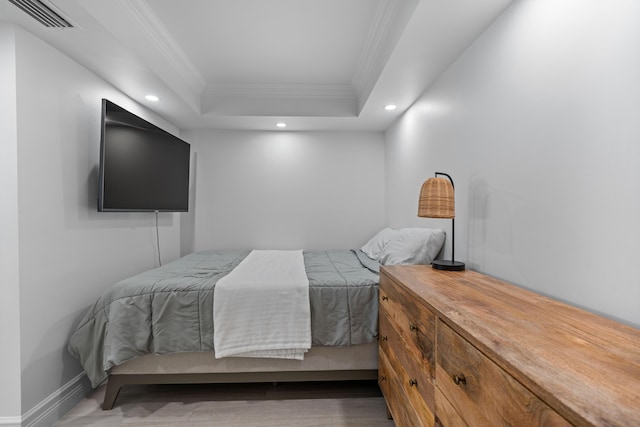 bedroom with recessed lighting, visible vents, baseboards, ornamental molding, and a tray ceiling