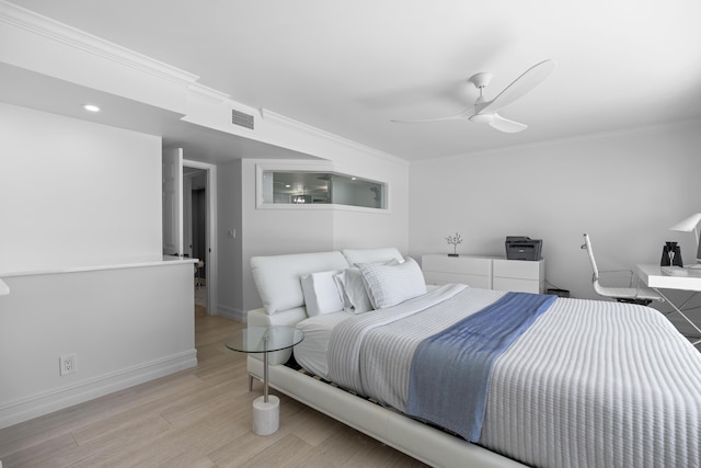 bedroom featuring a ceiling fan, baseboards, visible vents, light wood-style floors, and crown molding