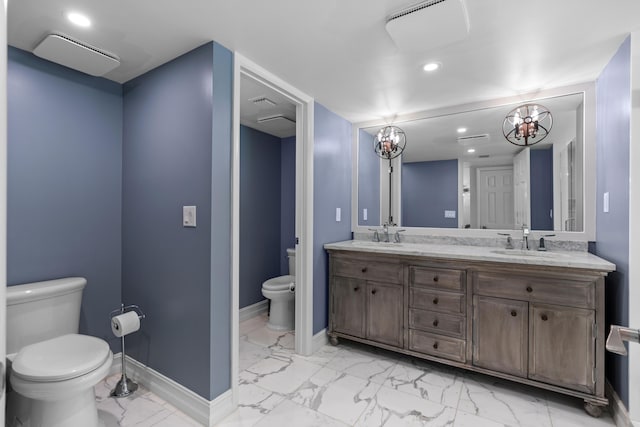 bathroom with marble finish floor, a sink, toilet, and baseboards