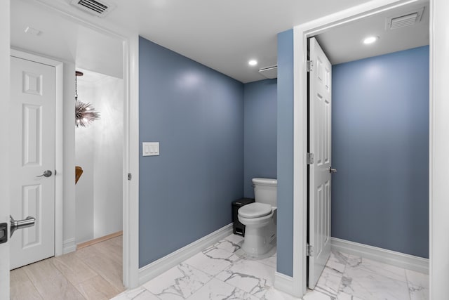 bathroom featuring toilet, marble finish floor, baseboards, and visible vents