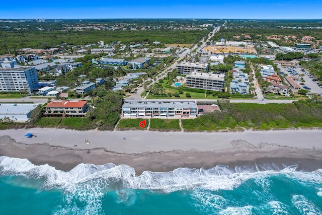 birds eye view of property featuring a water view and a beach view