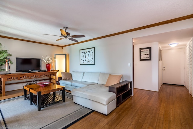 living room with wood-type flooring, a ceiling fan, and crown molding