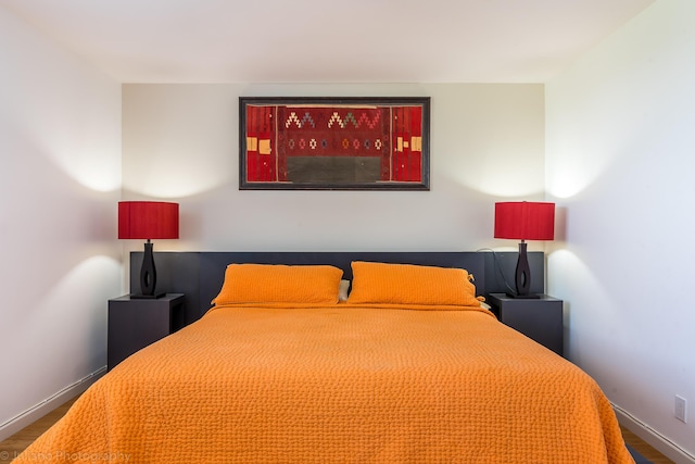 bedroom with baseboards and wood finished floors