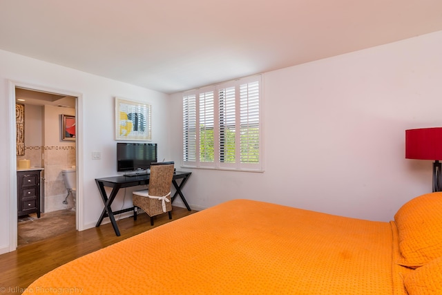 bedroom featuring wood finished floors and ensuite bathroom