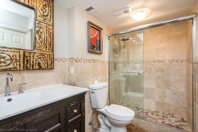 bathroom featuring visible vents, tile walls, toilet, and a shower stall