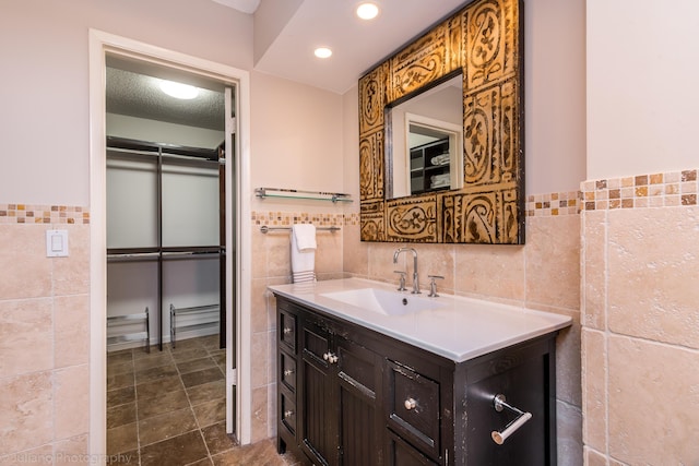 bathroom featuring recessed lighting, tile walls, a wainscoted wall, and vanity