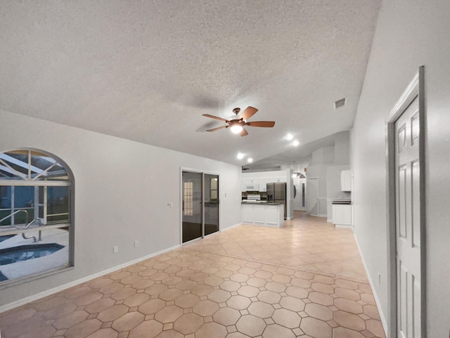 living area featuring lofted ceiling, ceiling fan, light tile patterned floors, a textured ceiling, and visible vents