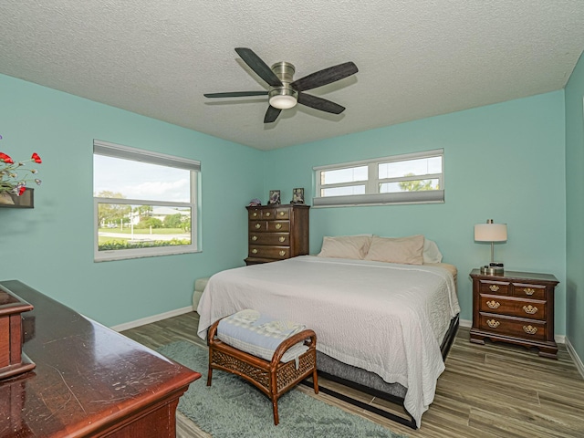 bedroom featuring multiple windows, wood finished floors, and baseboards