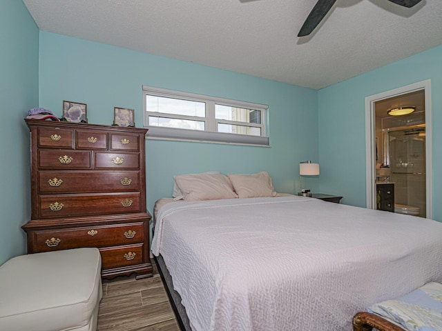 bedroom with a textured ceiling, a ceiling fan, wood finished floors, and ensuite bathroom