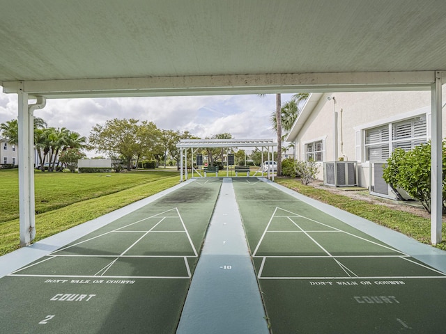 view of community with shuffleboard and a yard