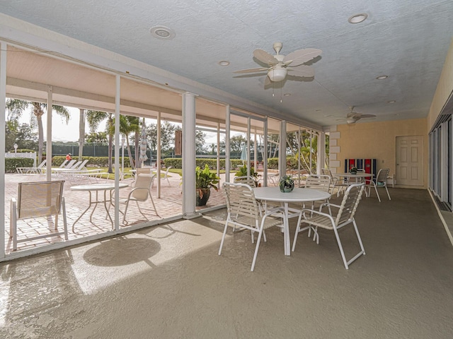 sunroom / solarium featuring a ceiling fan