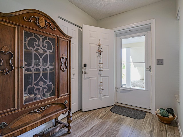 entryway featuring light wood-style floors and a textured ceiling