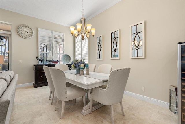 dining room with ornamental molding, a chandelier, and baseboards