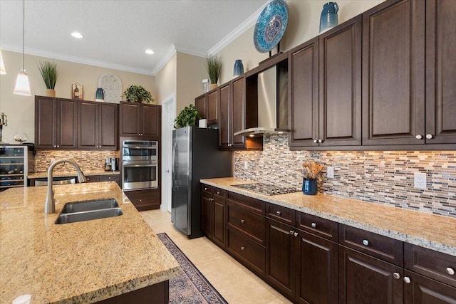 kitchen featuring appliances with stainless steel finishes, crown molding, dark brown cabinets, wall chimney range hood, and a sink