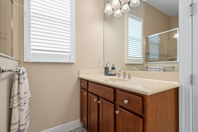 full bath with a shower, vanity, and baseboards