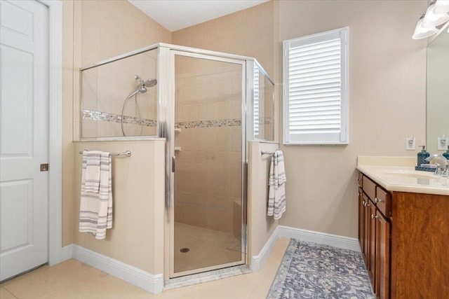 full bathroom with baseboards, a shower stall, vanity, and tile patterned floors