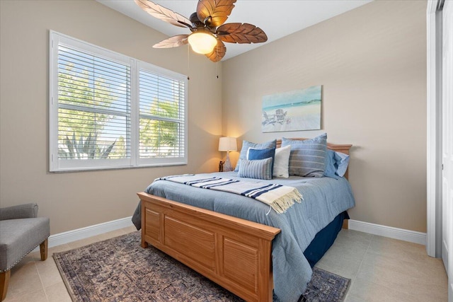 bedroom featuring light tile patterned floors, ceiling fan, and baseboards