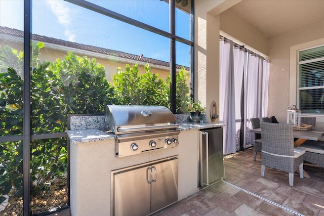 view of patio / terrace with area for grilling and a lanai