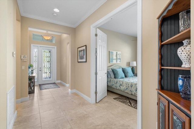 foyer entrance with light tile patterned flooring, crown molding, visible vents, and baseboards