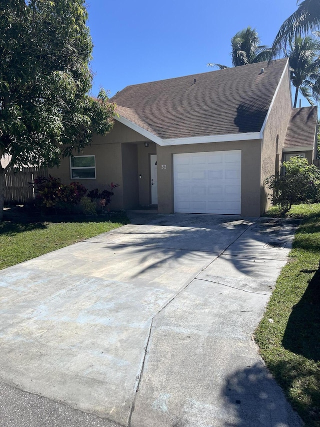 ranch-style home with stucco siding, an attached garage, roof with shingles, and driveway