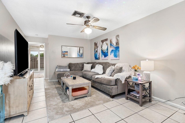 living room with light tile patterned floors, a ceiling fan, visible vents, and a textured ceiling